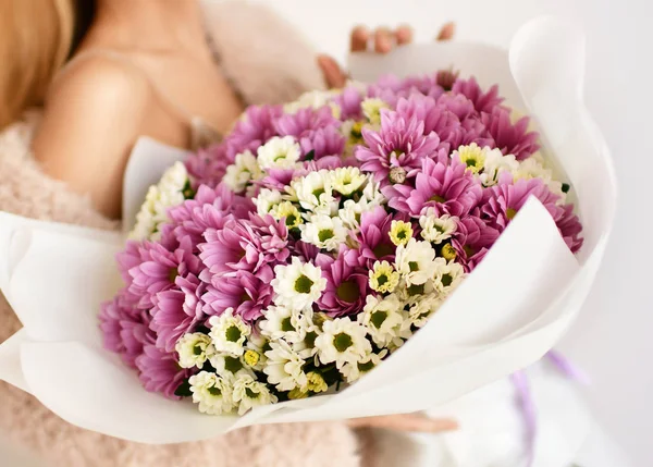 美しい女性に花束を持ちます菊の花の黄色と紫ホワイト — ストック写真