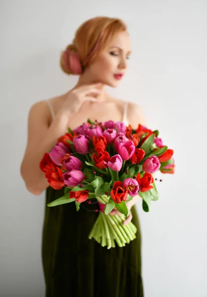 Gyönyörű nő hold vörös és rózsaszín tulipán virág csokor boldog, mosolyog a szürke — Stock Fotó