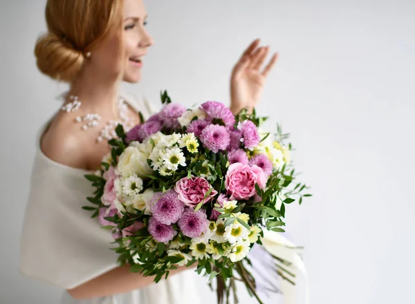 Gyönyörű nő hold krizantém és a rózsa virágok csokor fehér és lila boldog, mosolyog a szürke — Stock Fotó