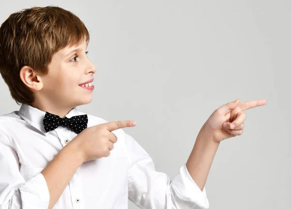 Jonge school jongen in wit overhemd wijzende vinger omhoog close-up samenstelling op grijs — Stockfoto