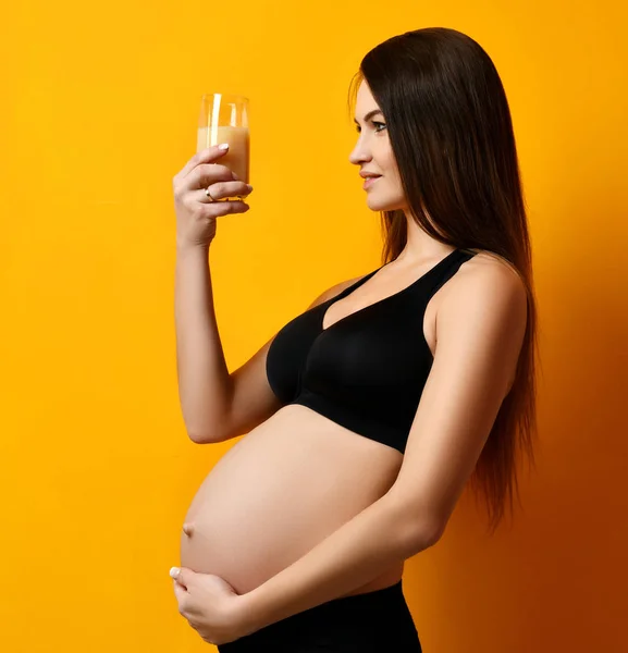 Młoda ciężarna matka szczęśliwa kobieta szczęśliwy uśmiechający się picia sok pomarańczowy, żółty — Zdjęcie stockowe