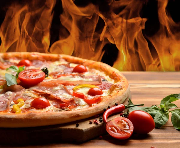 Pizza de pepperoni grande caliente sabrosa composición de pizza con queso derretido tocino tomates jamón pimentón vapor humo fuego — Foto de Stock