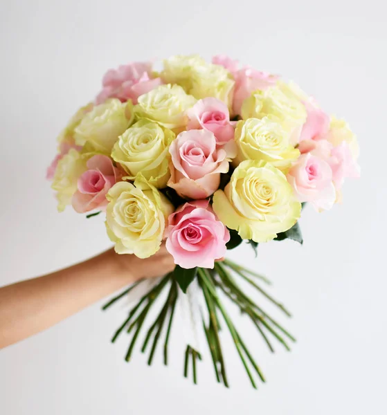 美しい女性の手が白黄色とピンクのバラの花の花束を保持します。 — ストック写真