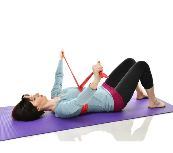 Woman exercising doing postnatal workout. Female fitness instructor working out with a rubber resistance band isolated on white — Stock Photo, Image