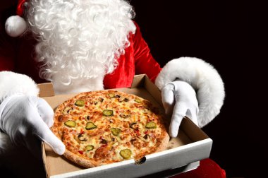 Mutlu Noel Baba 'nın elinde fotokopi alanı ile birlikte büyük, sıcak bir pizza var. Yeni yıl ve Xmas fast food