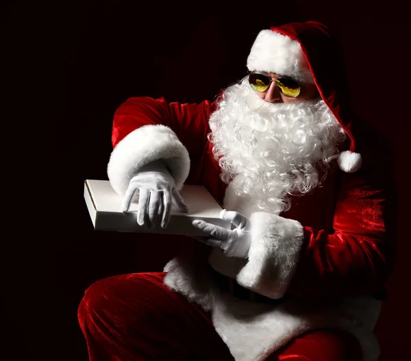 Papai Noel vai abrir um pacote de pizza, levantar uma tampa e pegar alguns, uma fatia, fortificar, comer. Ano Novo e Xmas fast food — Fotografia de Stock