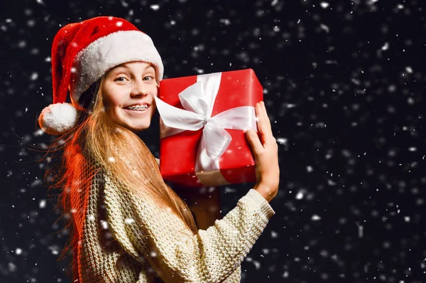 Teenager girl with braces holding hugging her new year gift red box with ribbon at her cheek happy to get under the snow — https://st3.depositphotos.com/1035122/32070/i/450/depositphotos_320702272-stock-photo-teenager-girl-with-braces-holding.jpg