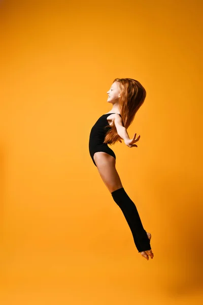 Young sport woman gymnastics doing jumping fitness exercise at sport gym jump on yellow — Stock Photo, Image