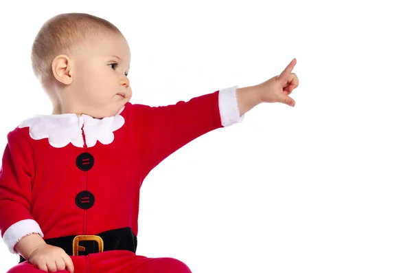 산타 클로스의 크리스마스 코스튬을 입고 손가락을 가리키며 무언가를만지고 있는 어린 남자 아이의 사진 — 스톡 사진