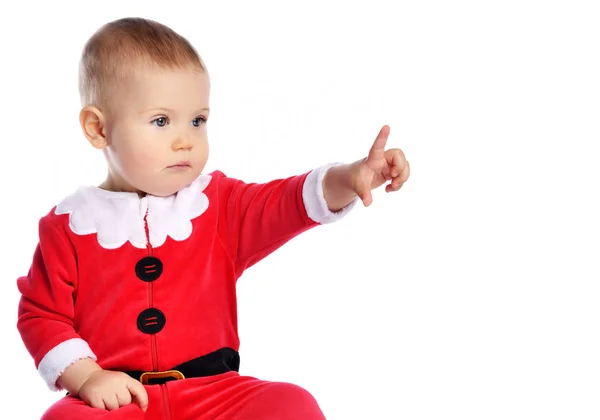 Portrét malého chlapečka batole v Santa Claus vánoční červený kostým ukazuje prstem na volné místo na bílém — Stock fotografie