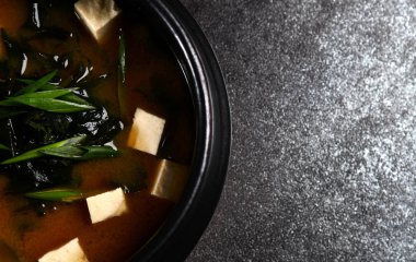 Japon miso çorbası, taşrada siyah bir kase içinde. 