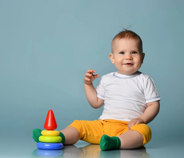 Infant baby boy toddler playing with a children multi-colored developing pyramid — Stock Photo, Image