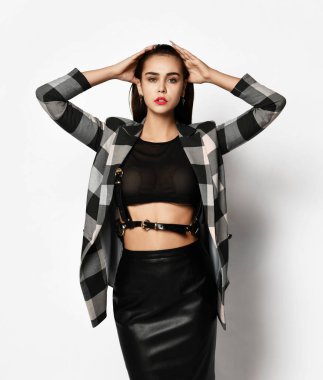 Kareli ceketli ve siyah etekli çekici modern kız kırmızı moda gözlüğü takıyor. 