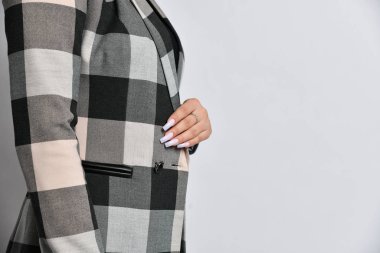 Gri düğümlü, sıradan bir ofis ceketi giymiş bir kadının yakın plan detayları. 