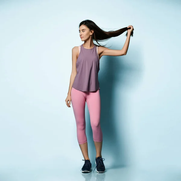 Beautiful sport woman in sportswear working out doing stretching sports exercises on light blue — 스톡 사진