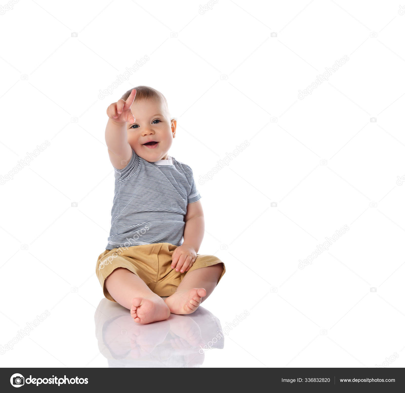 Niño bebé feliz en camiseta y pantalones está sentado en el suelo