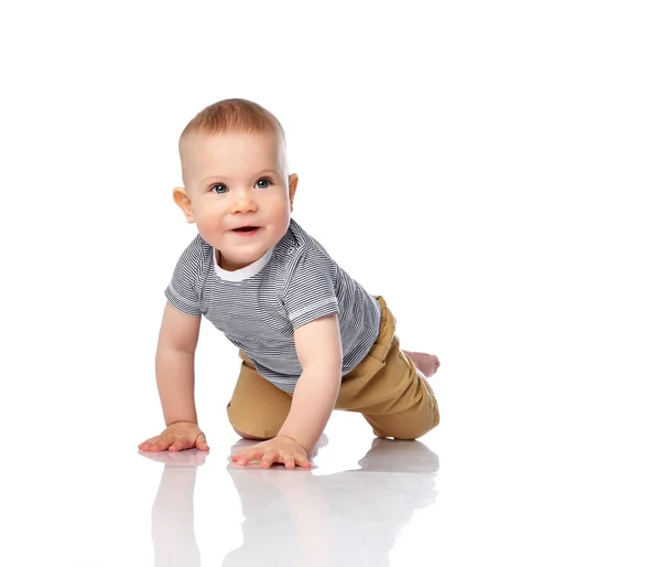 Curious infant boy toddler in t-shirt and green pants is crawling on all fours, looking copy space on white — Stok fotoğraf