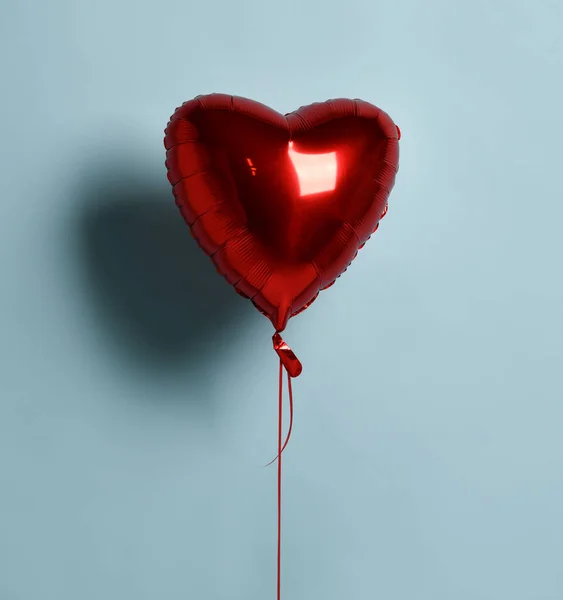 Metalowa folia pojedynczy czerwony obiekt balon serca na urodziny lub Walentynki na pastelowy kolor jasnoniebieski — Zdjęcie stockowe