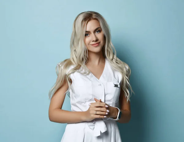 Portret van jonge mooie sexy lachende vrouw met lang blond golvend haar in witte jurk staande over blauwe muur — Stockfoto