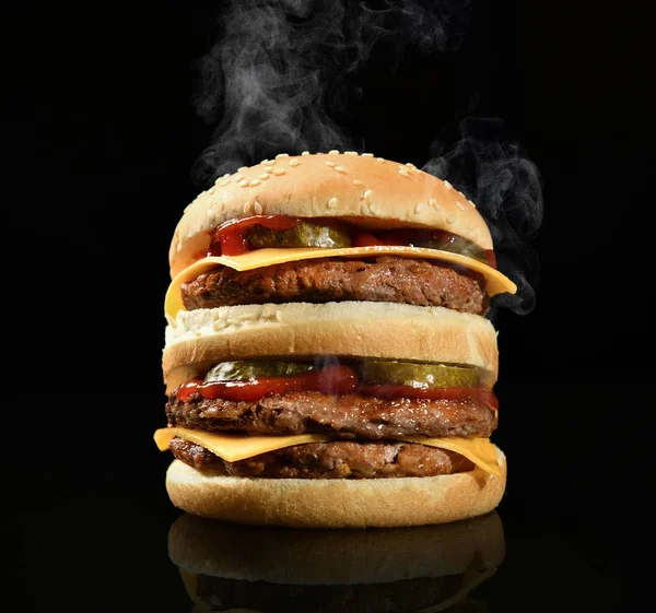 Potrójna kanapka z cheeseburgerem z serem wołowym, ogórkami i gorącym dymem parowym na czarno — Zdjęcie stockowe