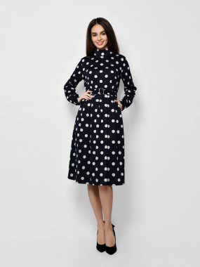 Genç, güzel bir kadın, yeni moda poz veriyor. Bahar mevsimi mavi benekli elbise, tüm vücut.