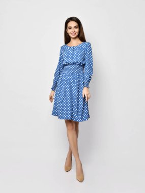 Genç, güzel bir kadın, yeni moda poz veriyor. Bahar mevsimi mavi benekli elbise, tüm vücut.