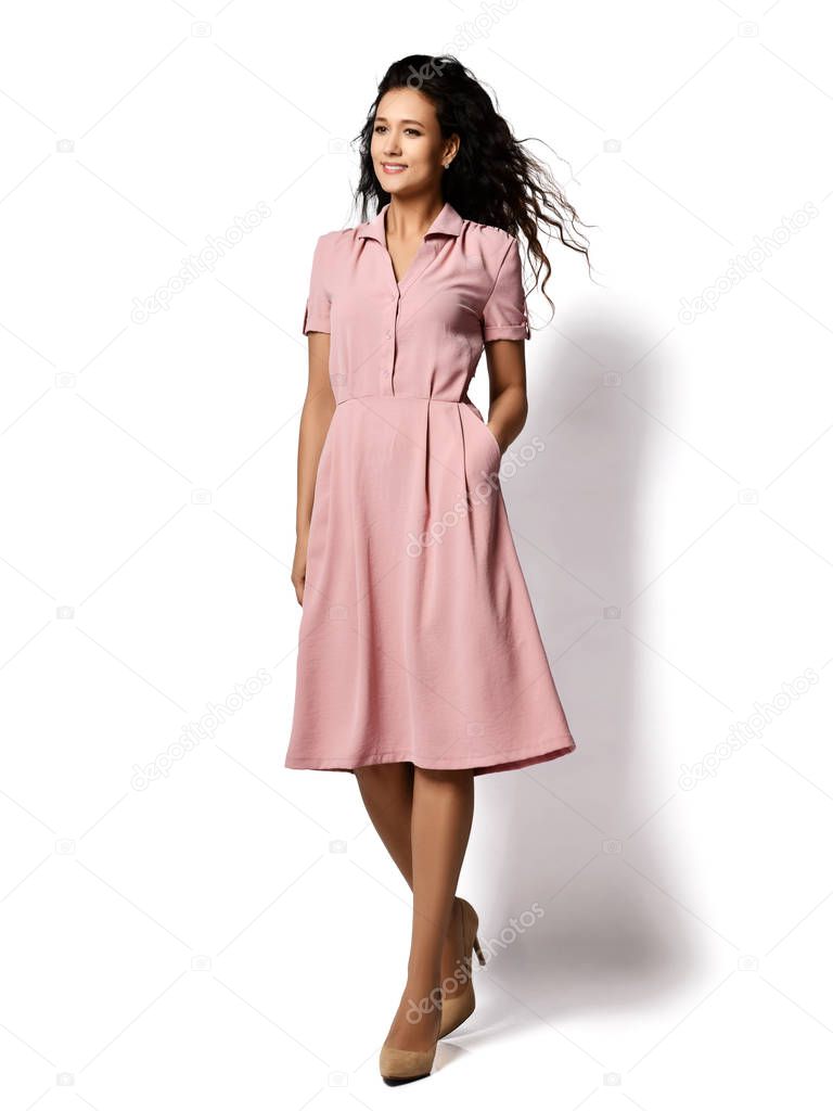 Young beautiful woman posing in new fashion casual pastel pink color dress happy smiling walking full body