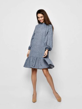 Genç, güzel bir kadın, yeni moda poz veriyor. Bahar mevsimi mavi benekli elbise, tüm vücut.