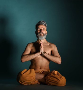 Gri sakallı yaşlı adam yoga, pilates, spor, esneme egzersizi, asana ya da yerde denge egzersizi yapıyor.
