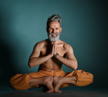 Gri sakallı yaşlı adam yoga, pilates, spor, esneme egzersizi, asana ya da yerde denge egzersizi yapıyor.