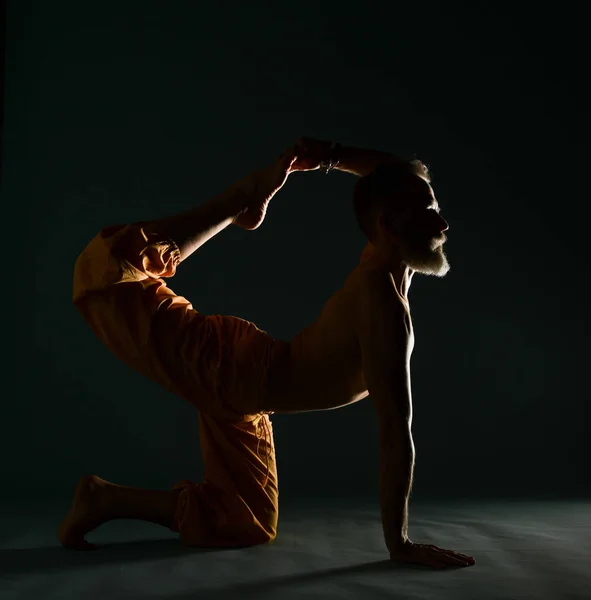 Alter Mann mit grauem Bart beim Yoga, Pilates, Fitnesstraining, Stretching, Asana oder Balancetraining am Boden — Stockfoto