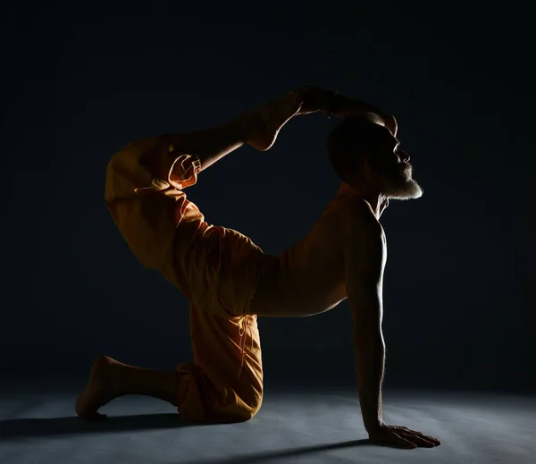Γέρος με γκρίζα γενειάδα που κάνει γιόγκα, πιλάτες, προπόνηση γυμναστικής, διατάσεις, asana ή ασκήσεις ισορροπίας στο πάτωμα — Φωτογραφία Αρχείου