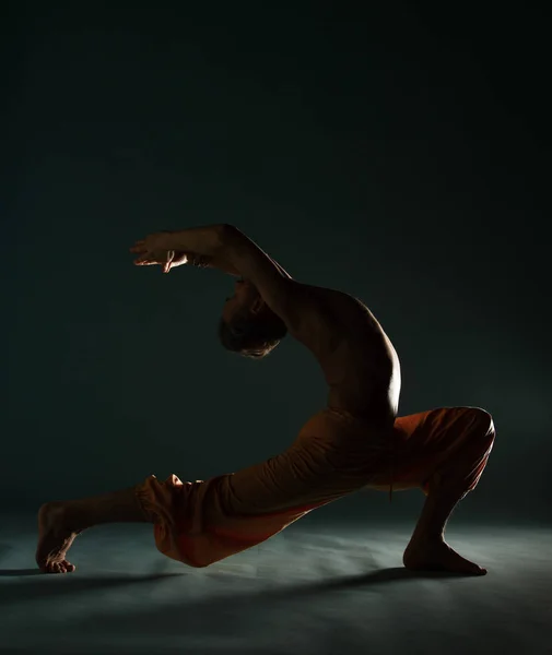 Le vieil homme à la barbe grise faisant du yoga, des pilates, de l'entraînement physique, des exercices d "étirement, de l'asana ou de l" équilibre au sol — Photo