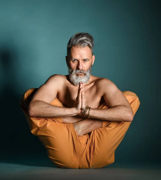 Old man with grey beard doing yoga, pilates, fitness training, stretching exercise, asana or balance workout on floor — Stock Photo, Image