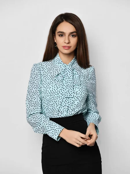 Portrait of young beautiful brunette business woman in stylish formal blouse shirt and black skirt over grey background — Stock Photo, Image
