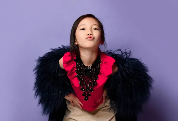 Alegre asiático coreano niña dama en elegante abrigo de piel, rosa camiseta y collar de lujo nos envía un beso sobre púrpura —  Fotos de Stock