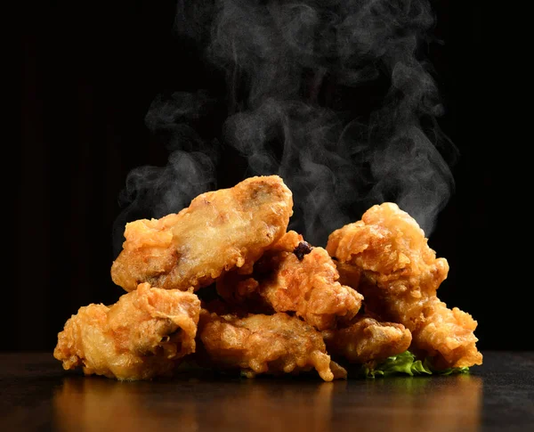 Alitas de pollo a la parrilla calientes y picantes con hojas de ensalada verde y humo de vapor — Foto de Stock