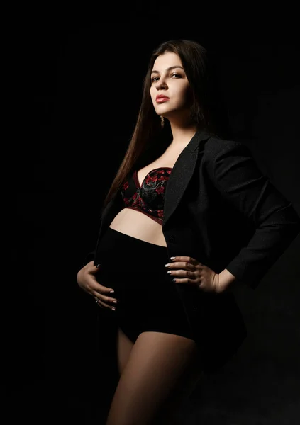 年轻而美丽的身材苗条的孕妇,留着一头长长的长发,背景是黑色的.怀孕的母亲，新生儿的预期寿命 — 图库照片