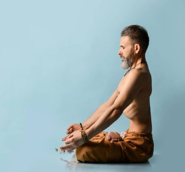Pantolon giyen, yoga, pilates, spor, esneme egzersizi, asana ya da denge egzersizi yapan yaşlı bir adam.