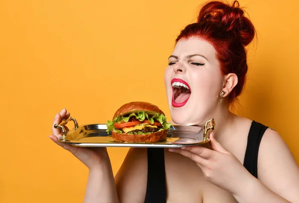 Feliz mulher gorda com sobrepeso feliz segurar hambúrguer cheeseburger sanduíche com carne bovina. Alimentação saudável dieta conceito fast food — Fotografia de Stock