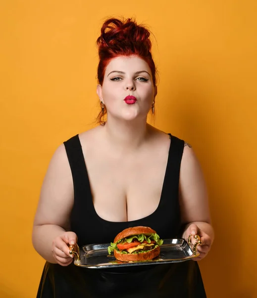 Счастливая толстая женщина счастливая держать бургер чизбургер сэндвич с говядиной. Концепция здорового питания — стоковое фото
