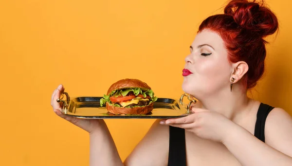 Feliz mulher gorda com sobrepeso feliz segurar hambúrguer cheeseburger sanduíche com carne bovina. Alimentação saudável dieta conceito fast food — Fotografia de Stock