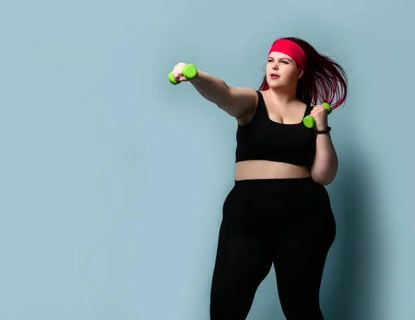 Фитнес здоровой концепции потери веса диеты. Счастливая девушка с избыточным весом, сидящая на диете и тренирующаяся с зелеными гантелями — стоковое фото