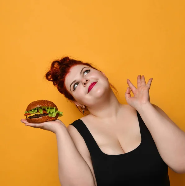 Gelukkige dikke vrouw met overgewicht houdt grote hamburger cheeseburger sandwich. Meisje op dieet. Gezond eten fastfood concept — Stockfoto