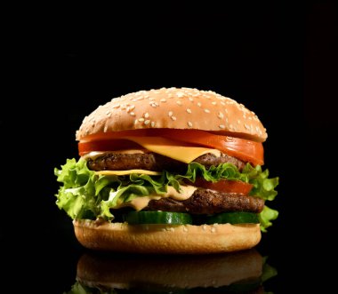 Biftek peynirli cheeseburger bbq sandviçi ve siyah buharlı taze sebzeler.