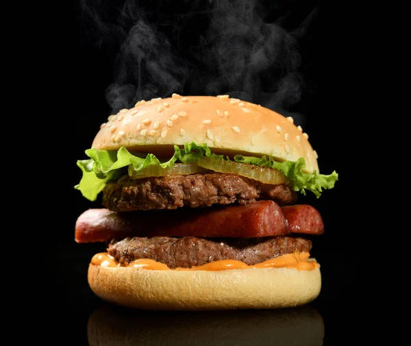 Burger cheeseburger sendvič s hovězím sýrem a čerstvou zeleninou horký párou kouř na černém — Stock fotografie