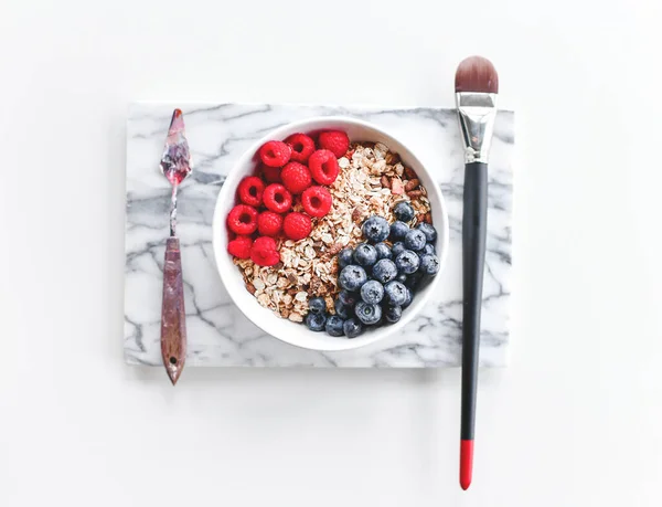 Art koncepció design reggeli. Művész festő kéz fogja paletta kés és festék ecset enni gabona zabkása bogyós gyümölcsök — Stock Fotó