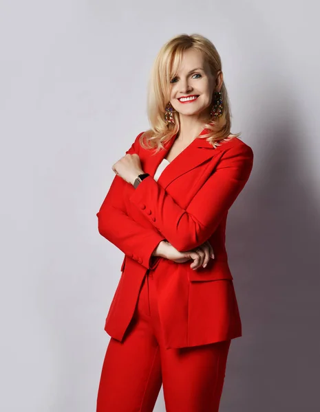 Portrait of young blond smiling businesswoman in stylish elegant deep red official suit and massive earrings — Stock Photo, Image