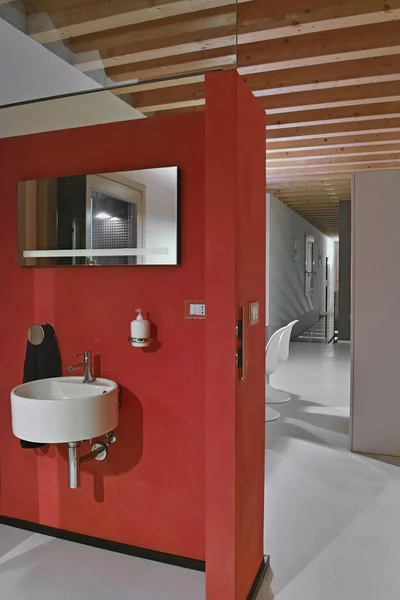 红色的墙后面有一个圆形的墙壁安装洗脸盆和 — 图库照片