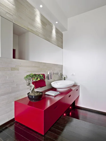 赤い洗面台のキャビネットの前のモダンなバスルームの内部ショット床は木で作られています — ストック写真
